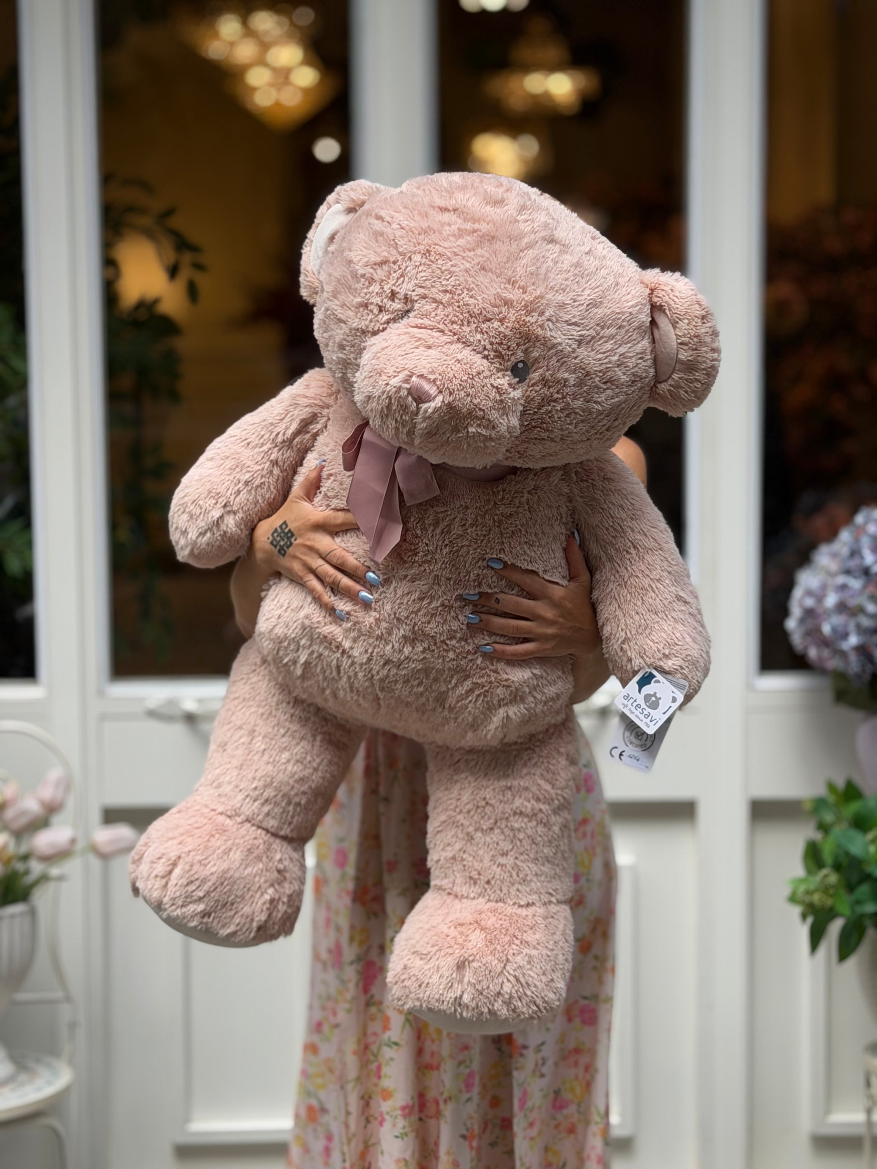 Oso de peluche grande rosa de 90 cm sostenido en brazos