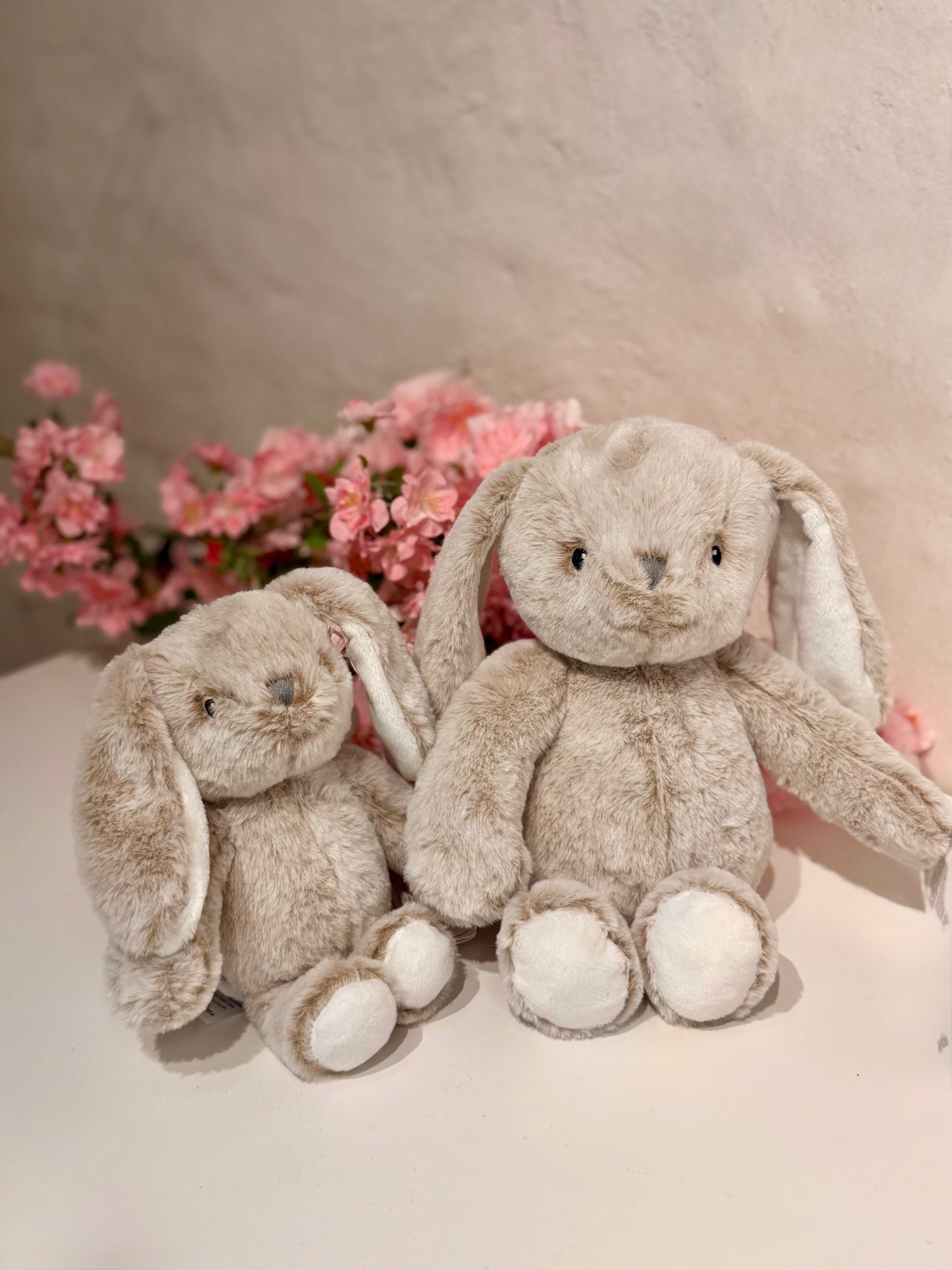 Conejos de peluche gris en tamaño pequeño y grande con flores rosas