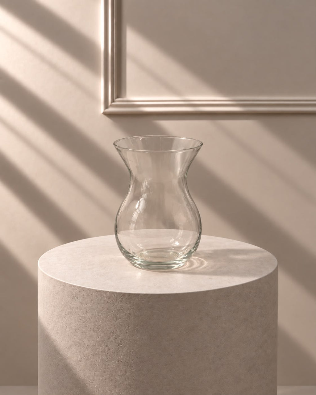 Jarrón Cristal Clásico transparente con silueta curvada y boca abierta, sobre pedestal de piedra