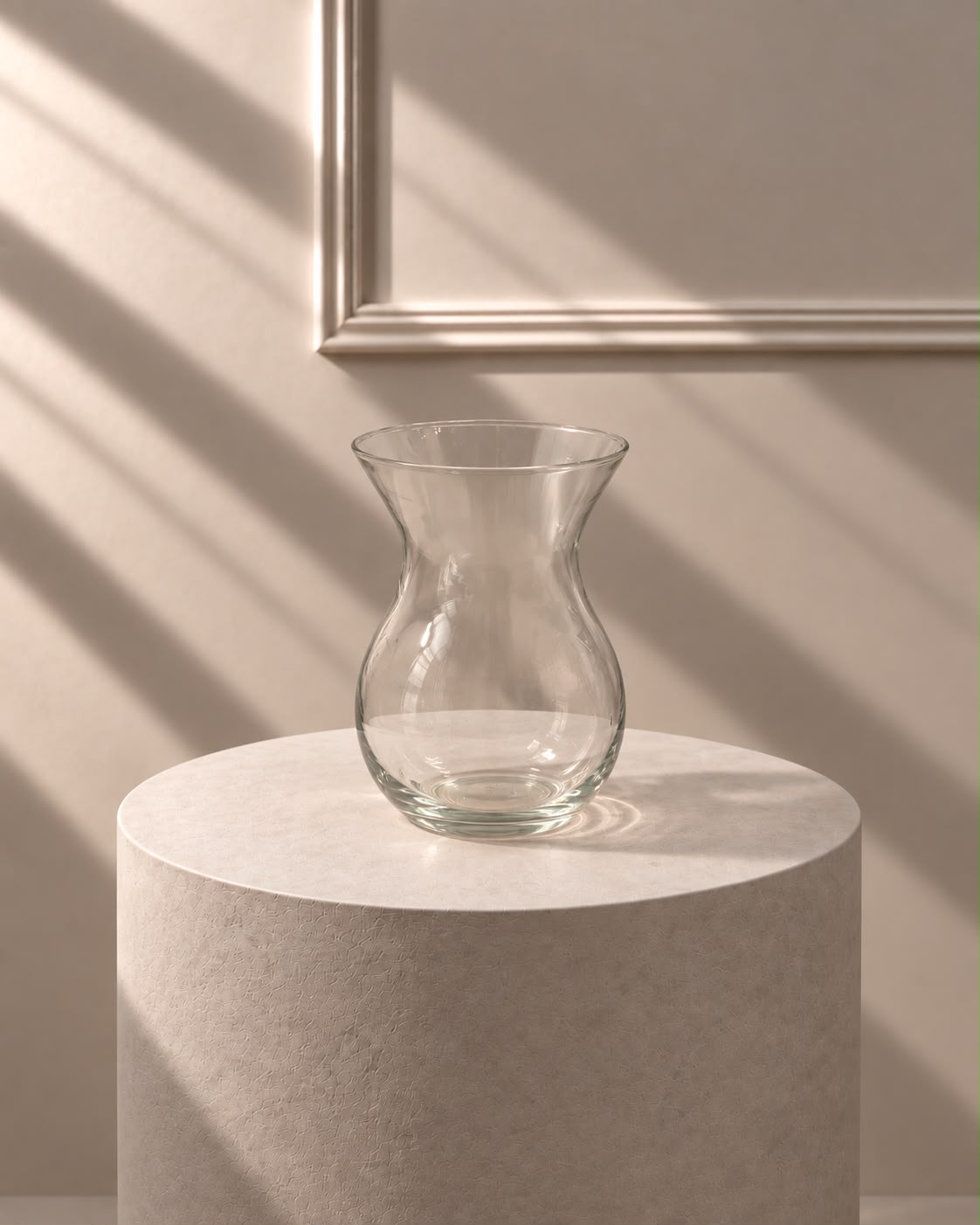 Jarrón Cristal Clásico transparente con silueta curvada y boca abierta, sobre pedestal de piedra