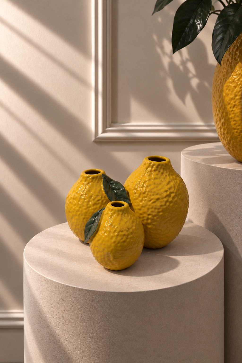 Jarrón Llimona amarillo sobre pedestal, formado por tres limones con hojas verdes en relieve.
