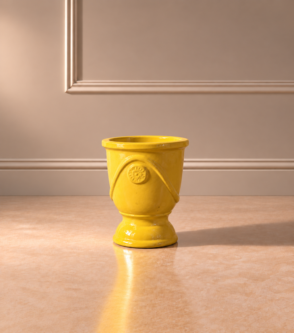 Jarrón Medallón Amarillo Pequeño con acabado esmaltado brillante, base de pedestal y detalle circular en relieve en la parte frontal.