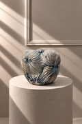 Jarrón Oceana Grande azul y blanco sobre pedestal, con silueta orgánica y relieve texturizado.