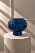Jarrón Azul Tesoro de EDG, jarrón decorativo azul con relieve ornamental sobre pedestal beige