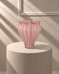 Jarrón Pétalo Rosa de vidrio rosa con relieve vertical y borde ondulado, presentado sobre pedestal beige